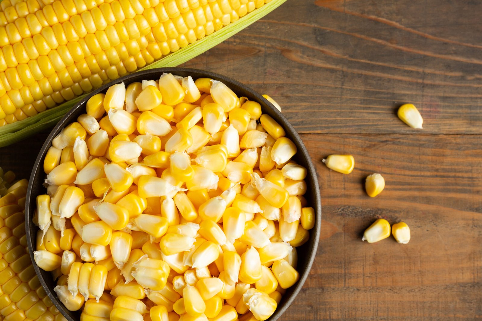 seeds and sweet corn on wooden table.