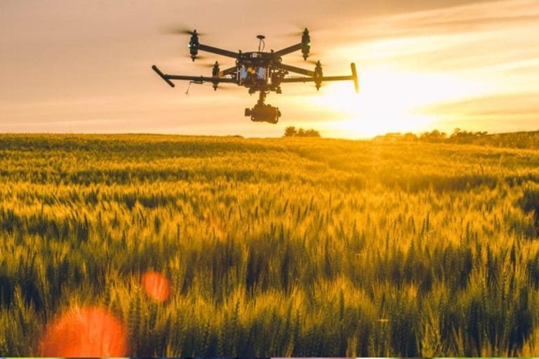 Drone sobrevoando lavoura para monitoramento e pulverização de precisão