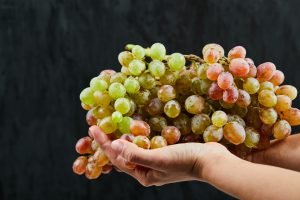 A bunch of fresh grapes in hand on black background. High quality photo