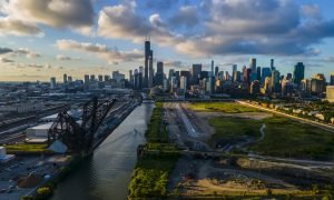 aerial drone shot of Chicago beautiful metropolis skyline during sunset along the river.  the cloud are vibrant with color as the city architecture
