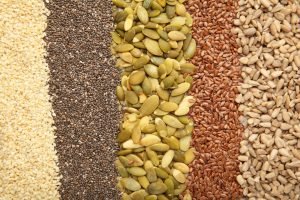 Healthy superfood: sesame, pumpkin seeds, sunflower seeds, flax seeds and chia background. Seeds on spoon. Top view