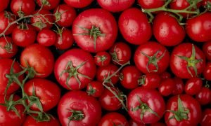 top view of ripe fresh tomatoes with water drops on black background