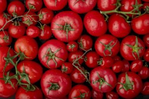 top view of ripe fresh tomatoes with water drops on black background