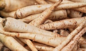White parsnip or parsley roots displayed on street food market, closeup detail